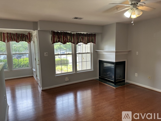 A living room with a fireplace and a ceiling fan.