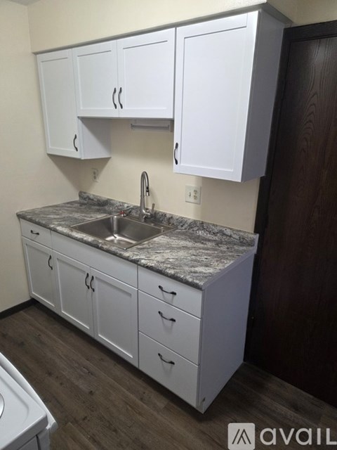 A kitchen with a black fridge, stove, and microwave.