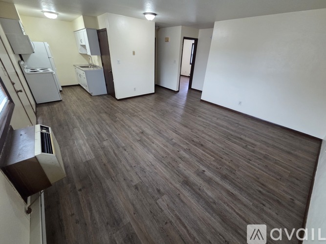 A kitchen with wooden floors and black appliances.