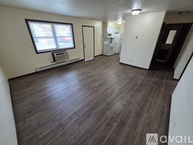 A room with wooden flooring and white walls.