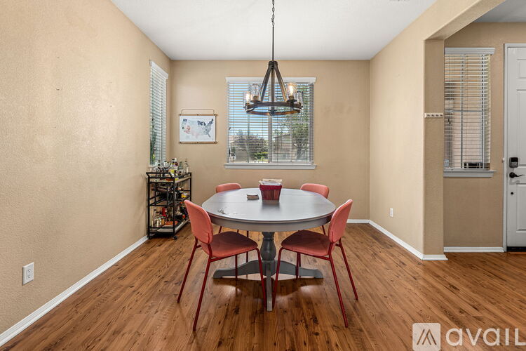 A dining room with a table and chairs.