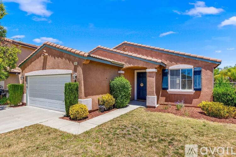 A house with a brown stucco exterior and a blue garage door.