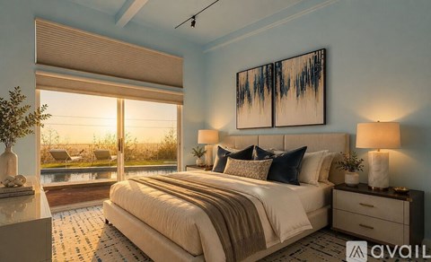 A bedroom with a large bed and a view of the outdoors through a window.