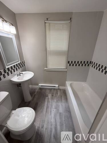 A bathroom with a toilet, sink, and bathtub.