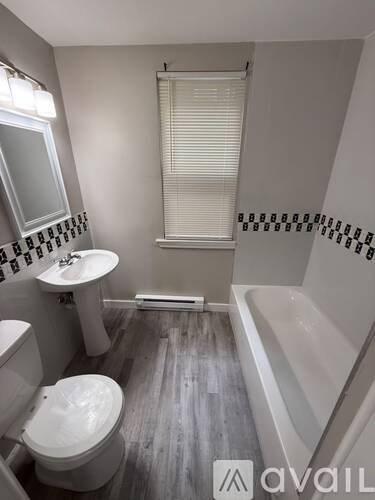 A bathroom with a toilet, sink, and bathtub.
