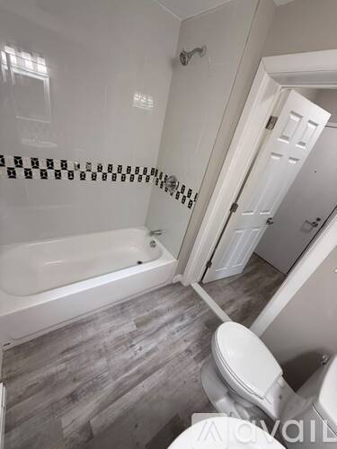 A bathroom with a white tub and toilet.