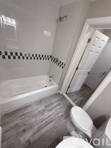 A bathroom with a white tub and toilet.