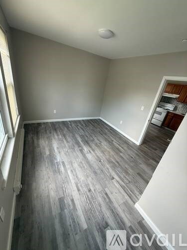 A room with grey wooden flooring and white walls.