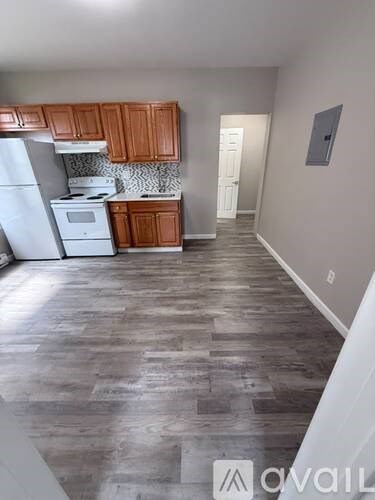 A kitchen with wooden cabinets and a white fridge.