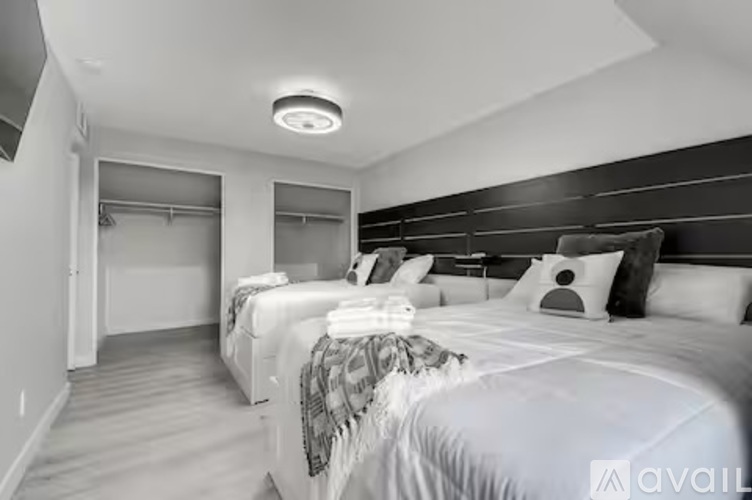 A bedroom with two beds and a ceiling light.