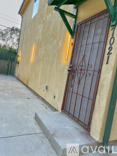 A yellow building with a brown door and a green awning.