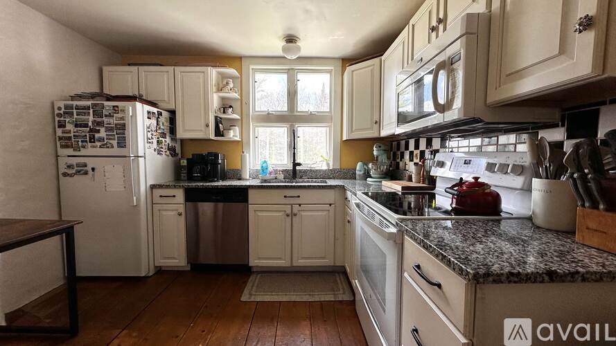 A kitchen with white cabinets and appliances.
