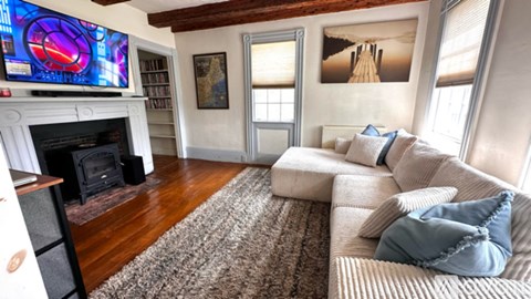 A living room with a fireplace and a television on the wall.