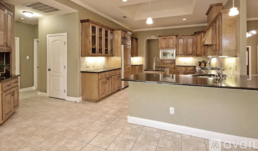 A kitchen with wooden cabinets and a tiled floor.