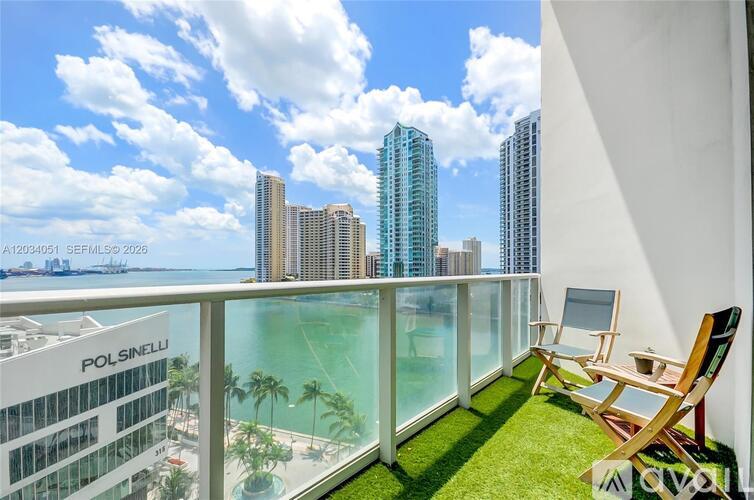 A balcony with chairs and a view of the city.