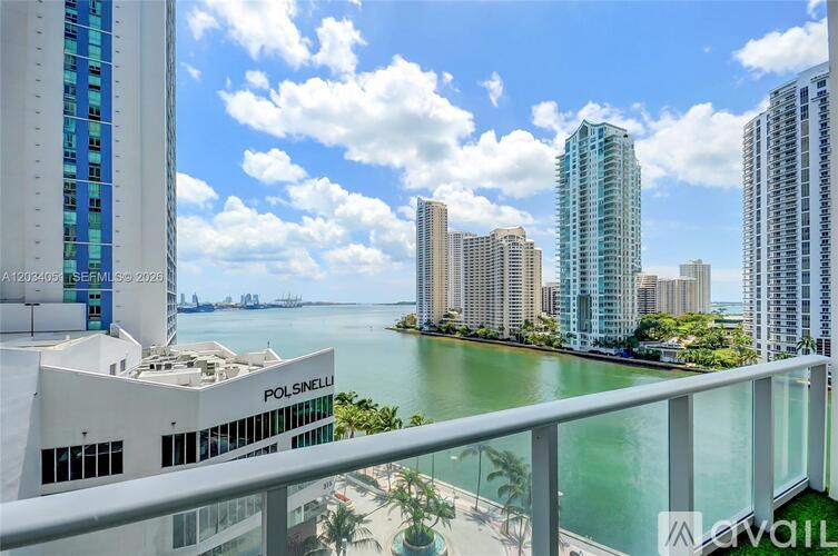 A view of a cityscape with a body of water in the foreground and a building with the name "POLSENI" on it.
