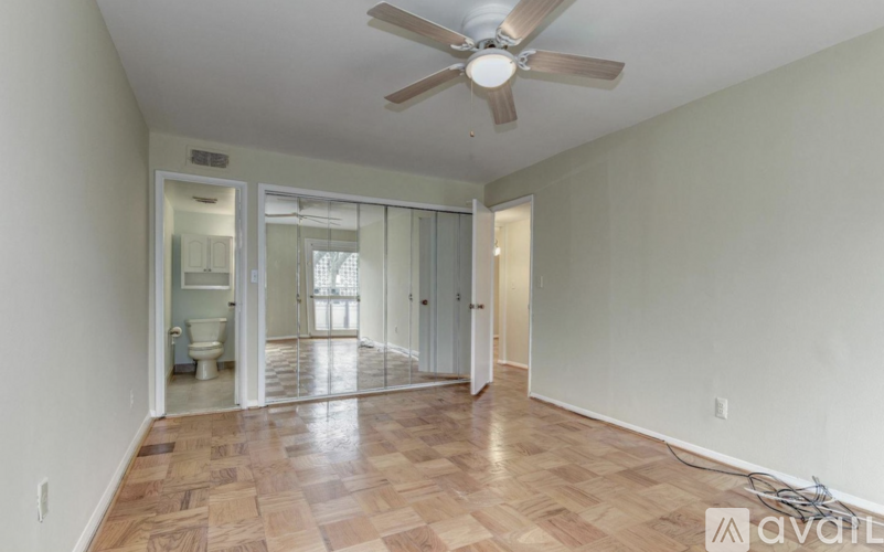 A room with a ceiling fan and wooden flooring.