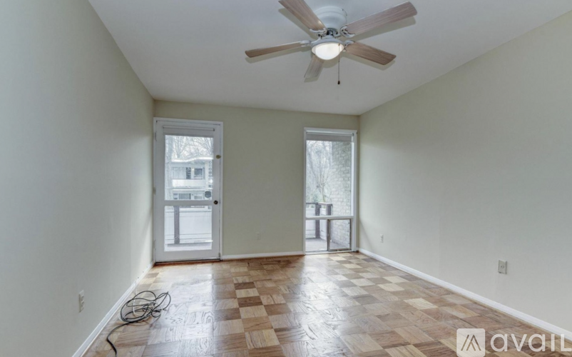 A room with a ceiling fan and a checkerboard floor.