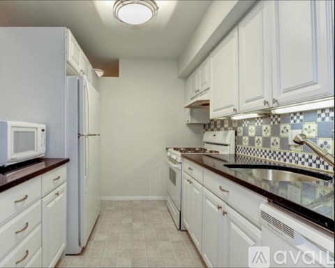 A kitchen with white cabinets and appliances.