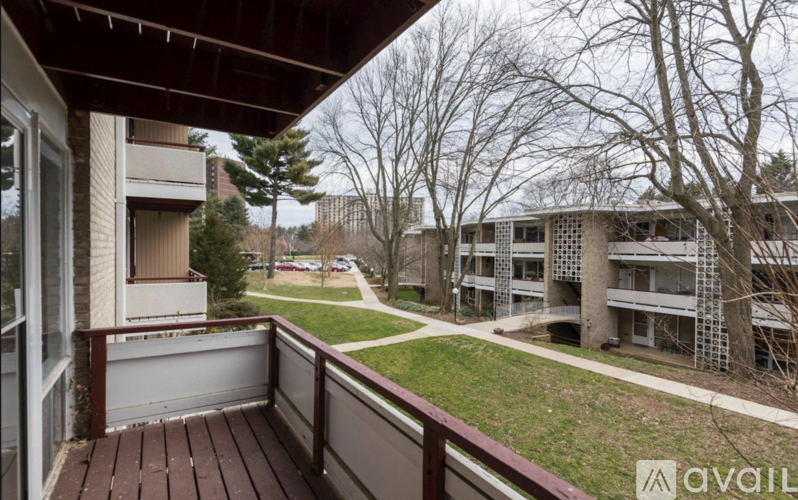 A balcony with a view of apartment buildings and trees.