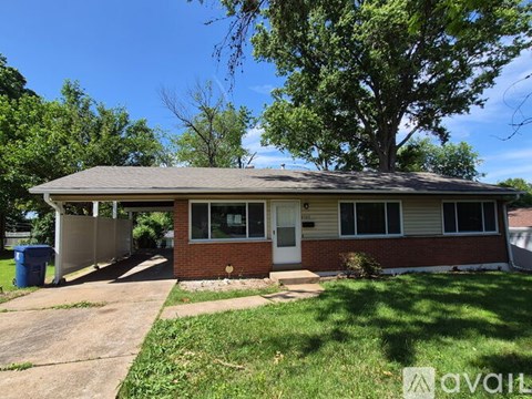 A house with a red brick exterior and a white door is for sale.