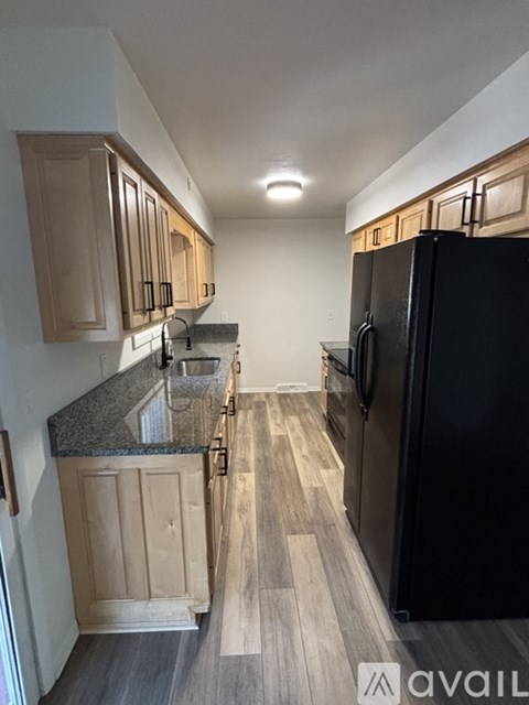 A kitchen with black appliances and wooden cabinets.