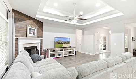 A living room with a grey couch and a flat screen TV.