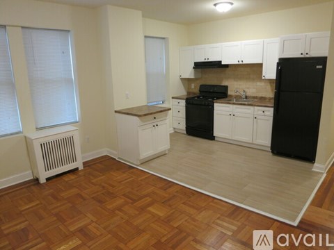A kitchen with black appliances and wooden floors.