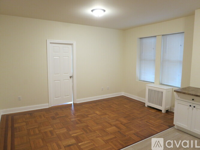 A room with a wooden floor and a white door.