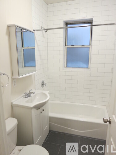 A white bathroom with a toilet, sink, and bathtub.