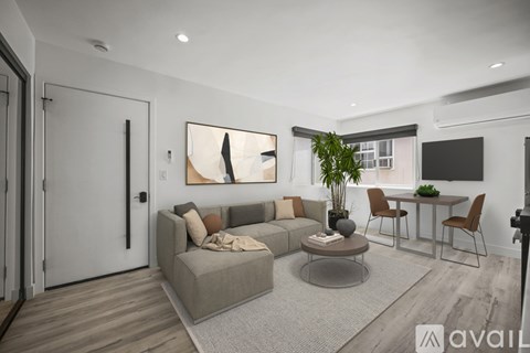 A living room with a grey sofa, a coffee table, and a dining table with chairs.