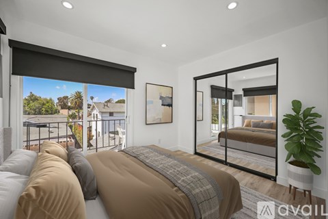 A bedroom with a large bed and a view of the outdoors through the window.