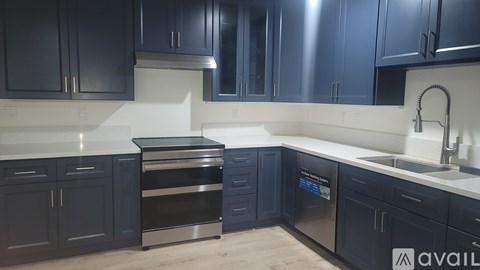 A kitchen with dark blue cabinets and stainless steel appliances.