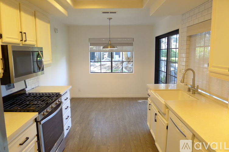 A kitchen with white cabinets and a black stove top oven.