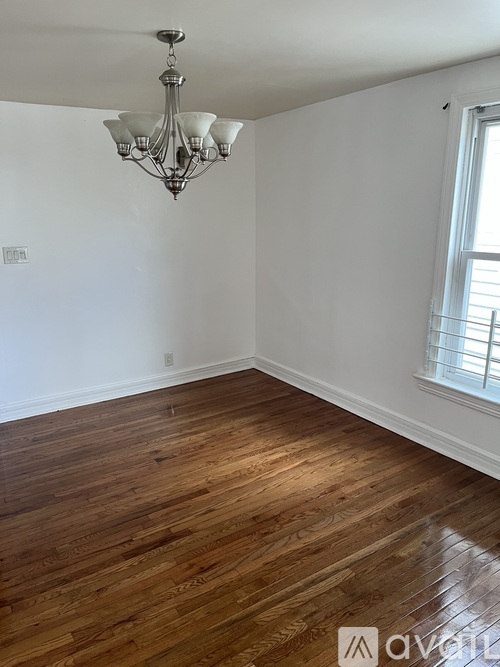 A room with wooden floors and a chandelier.