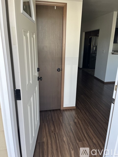 A wooden door is in the middle of a hallway.