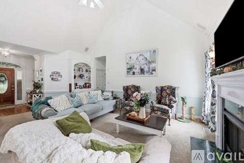 A living room with a white couch and a fireplace.