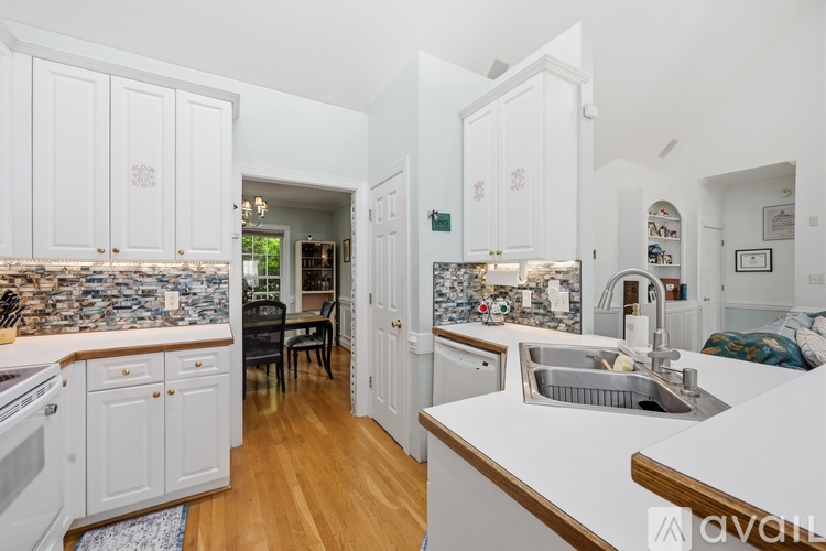 A kitchen with white cabinets and a wooden island.