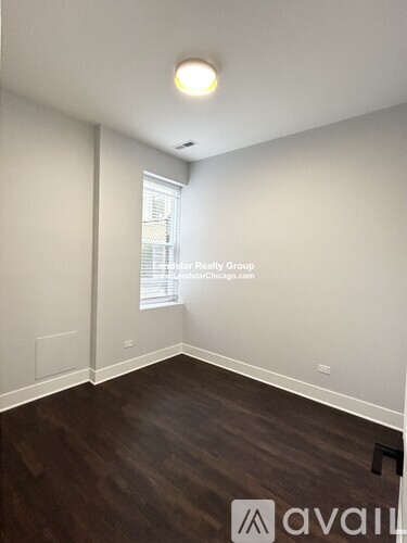 A room with wooden flooring and white walls.