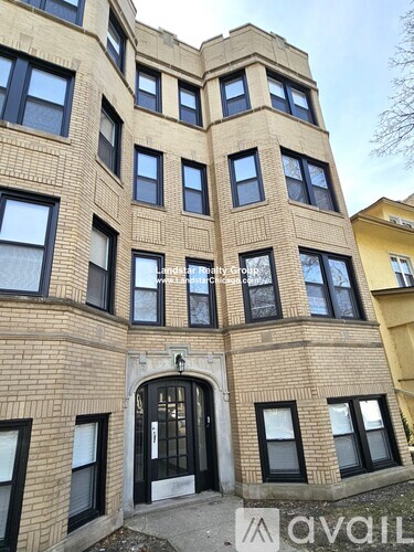 A large brown building with many windows and a black door.