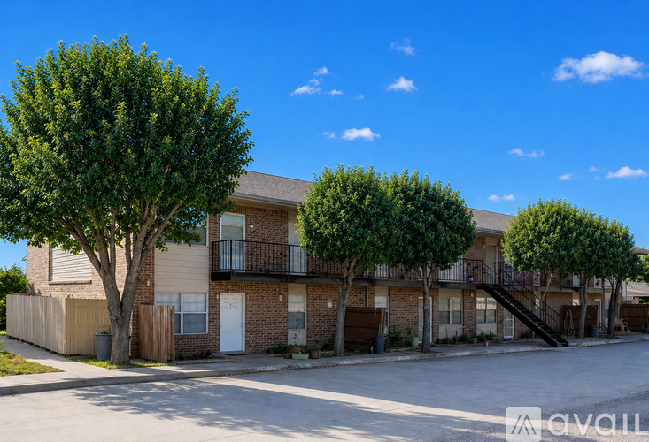 Apartment complex with a tree in front of it.