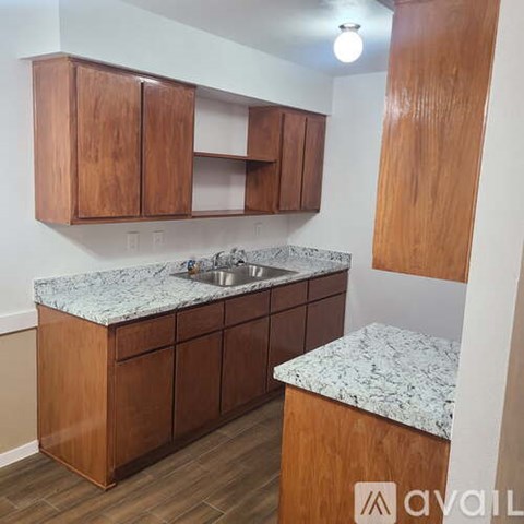 A kitchen with wooden cabinets and a marble countertop.