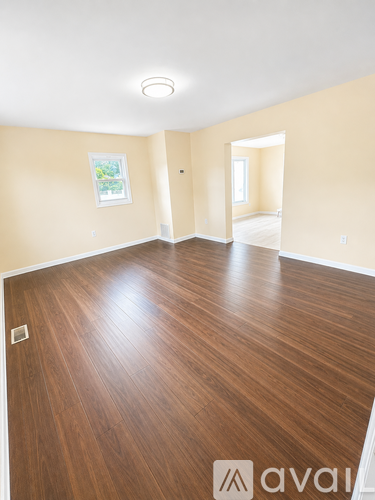 A room with wooden flooring and a painting on the wall.
