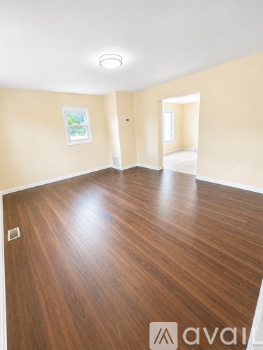 A room with wooden flooring and a painting on the wall.