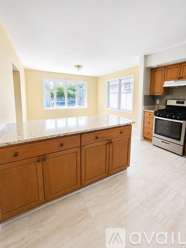 A kitchen with wooden cabinets and a marble countertop.