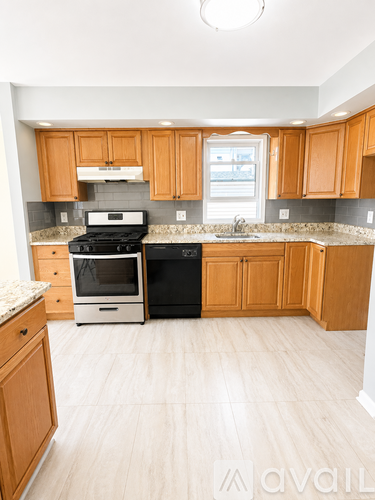 A kitchen with wooden cabinets and a black stove top oven.