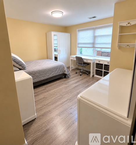 A bedroom with a bed, desk, and chair.