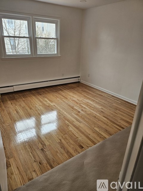 A room with wooden flooring and a window.