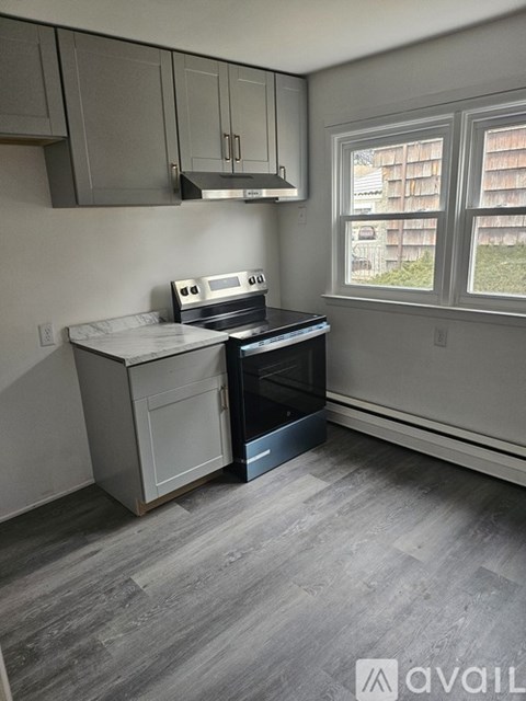 A kitchen with a stove and oven built into a cabinet.