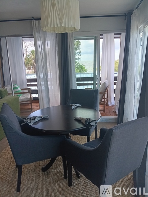 A table with chairs in front of a window with curtains.